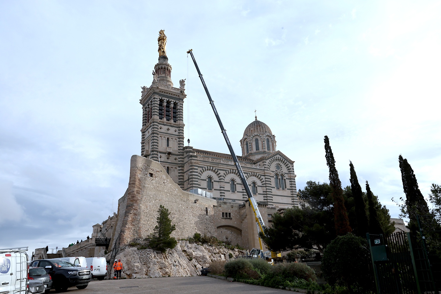 Présentation à la presse du chantier de restauration de Notre-Dame de la Garde qui devrait durer huit mois Le grand symbole religieux de la ville de Marseille : la Bonne-Mère la basilique qui surplombe la cite phoceenne est visitee par plus de 2,3 millions de visiteurs chaque annee. Un batiment religieux qui se prepare a un immense lifting. Ce mardi matin debutait l'installation de l immense echafaudage. Une equipe reduite s occupera de la statue de la Vierge sur le clocher qui se verra appliquer pas moins de 40.000 feuilles d or. Hors de question de fermer le site durant sa restauration. Les acces seront donc regules, mais toujours possible, rassure le diocesea Marseille le mardi 10 fevrier 2025.